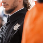 partial view of bearded bailiff in black uniform in court