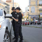 Patrolman and patrolwoman team checking driving license during traffic stop